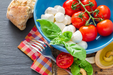 Caprese salad ingredients on dark stone background
