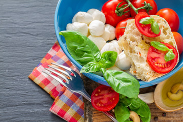 Caprese salad ingredients on dark stone background