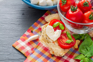 Caprese salad ingredients on dark stone background
