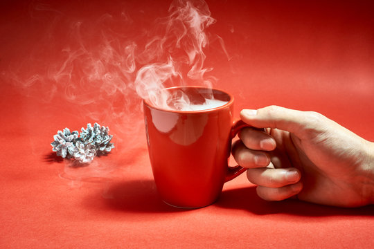 A man holding a cup of hot coffee