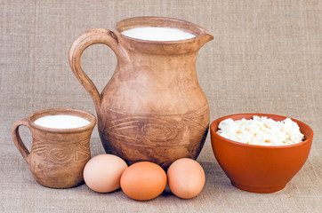 Clay jug and cup of milk, eggs and curds