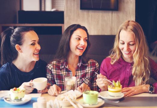 Three Young Women At A Meeting In A Cafe