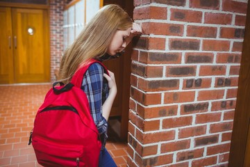 Worried student leaning against the wall