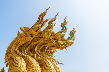 Fototapeta na wymiar serpent king or king of naga statue in thai temple on blue sky background 