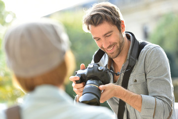 Photographer taking picture of trendy model in park