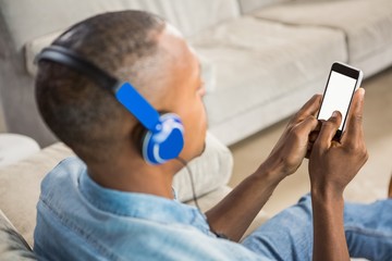 Over shoulder view of casual man listening music