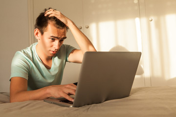 Worried man in front of the laptop at home.