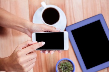 Overhead of feminine hands using smartphone