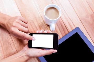 Businesswoman using her smartphone on desk