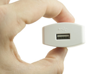 Caricatore usb bianco da muro visto di fronte e tenuto tra le dita