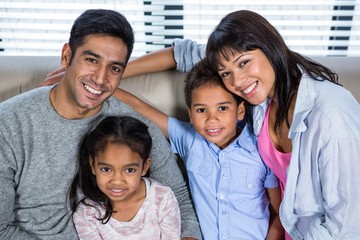 Happy young family posing together on the couch