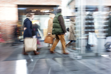 Fototapeta premium Group of people walking in shopping centre, zoom effect, motion