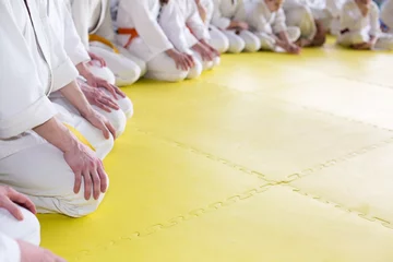 Foto op Plexiglas Vechtsport Mensen in kimono zittend op tatami op martial arts seminar