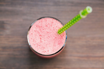 A glass of fresh watermelon smoothie on wooden background
