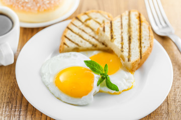 Fried eggs with coffee and dessert on breakfast. International cuisine.