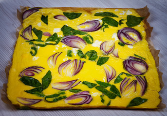 Omelette with blue onion and spinach on parchment