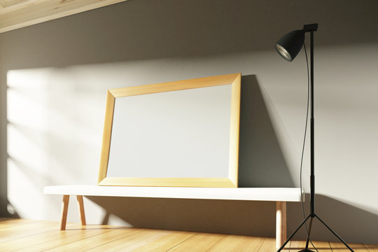 Blank wooden picture frame in a sunny gallery with benches and l