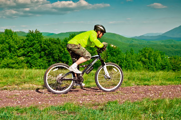Obraz premium Cyclist riding a bike on the mountain