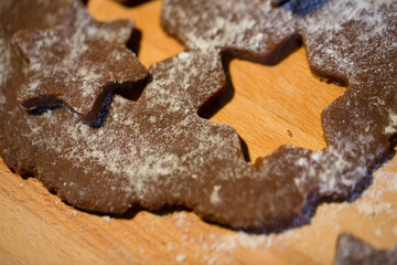 close up of ginger dough, molds and flour on board