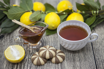Beautiful composed on wooden background Cup of tea lemon and biscuits
