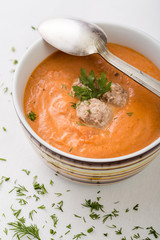 tomatoe soup with meatballs in bowl with spoon