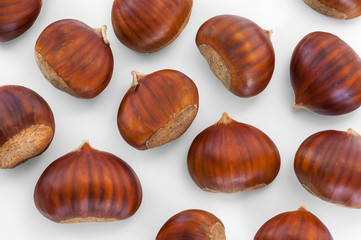 Texture of many chestnuts on white background, autumn decoration
