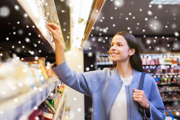 happy woman choosing and buying food in market