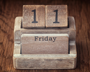 Grunge calendar showing Friday the eleventh on wood background
