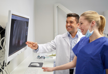 Obraz premium dentists with x-ray on monitor at dental clinic
