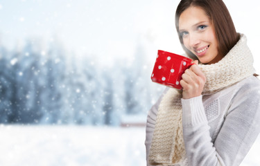 Beautiful brunette woman with cup in winter scenery