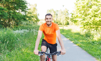 Obraz premium happy young man riding bicycle outdoors