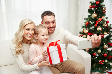 Obraz na płótnie Canvas family taking selfie with smartphone at christmas