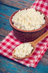 Fresh cottage cheese in a ceramic dish and spoon