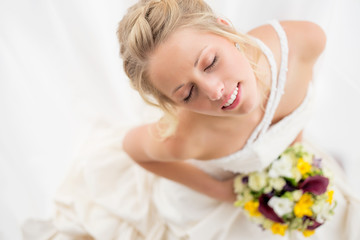 Obraz na płótnie Canvas Happy bride holding her wedding bouquet