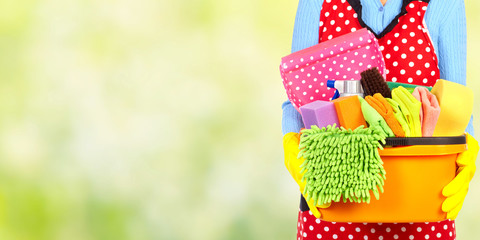 Maid hands with cleaning tools.