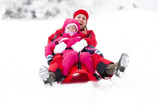 sledding mother and her little daughter