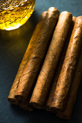 Cigars with alcohol on dark background