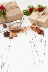 Christmas background with presents, fir branches and spices on the old wooden board with copy space