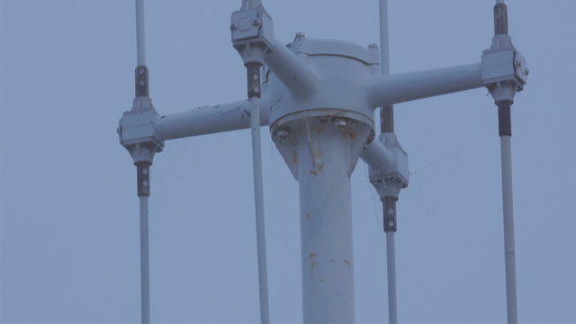 A lighthouse and the anemometer on the tower. An anemometer is a device used for measuring wind speed and is a common weather station instrument.