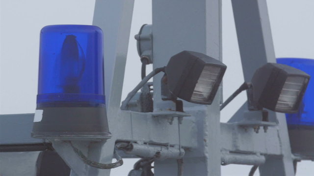 Blue siren light and lightings on the tower. It is on the ship dock on the port