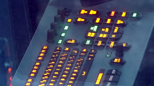 A captains deck on the ship. It has lots of lighted buttons that is orange in color