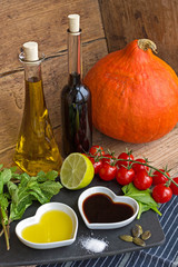 Oil and vinegar in heart shaped bowls with fresh produce