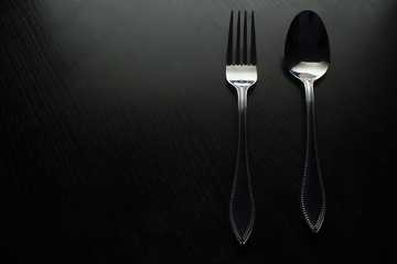 fork and spoon on a black table