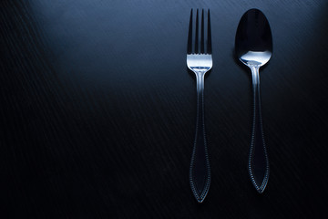 fork and spoon on a black table