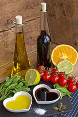 Oil and vinegar in heart shaped bowls with fresh produce