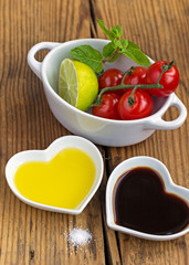 Oil and vinegar in heart shaped bowls with fresh produce
