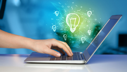 Close up of hand with laptop and  idea bulb