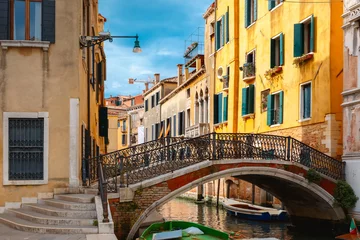 Fototapeten Bunter Seitenkanal und Brücke in Venedig, Italien © Kavalenkava