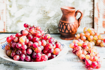Fresh red grapes on the plate, raw fruits, whole plant foods