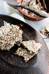 crackers from flax seed, sesame, sunflower and spices on a dark
